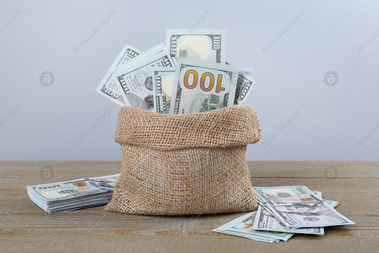 Photo of Dollar banknotes in bag on wooden table