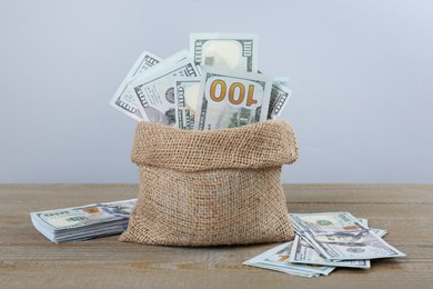 Dollar banknotes in bag on wooden table