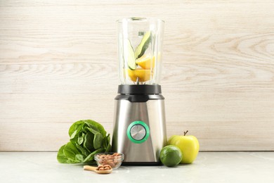 Photo of Blender and products on grey marble table