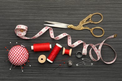 Different sewing tools on wooden table, flat lay