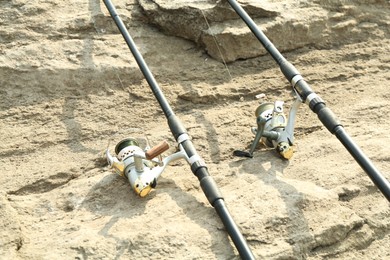 Two fishing rods on ground outdoors, closeup