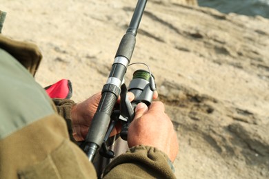 Fisherman with rod fishing near lake at summer, closeup