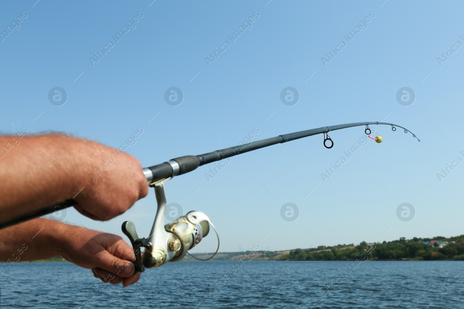 Photo of Fisherman with rod fishing near lake at summer, closeup