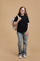 Photo of Teenage girl with backpack on beige background