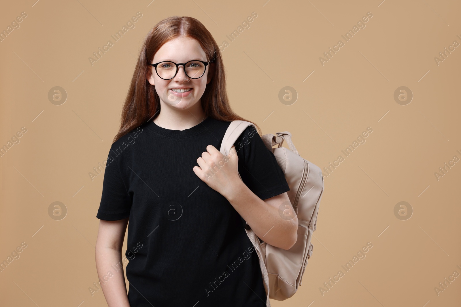 Photo of Teenage girl with backpack on beige background