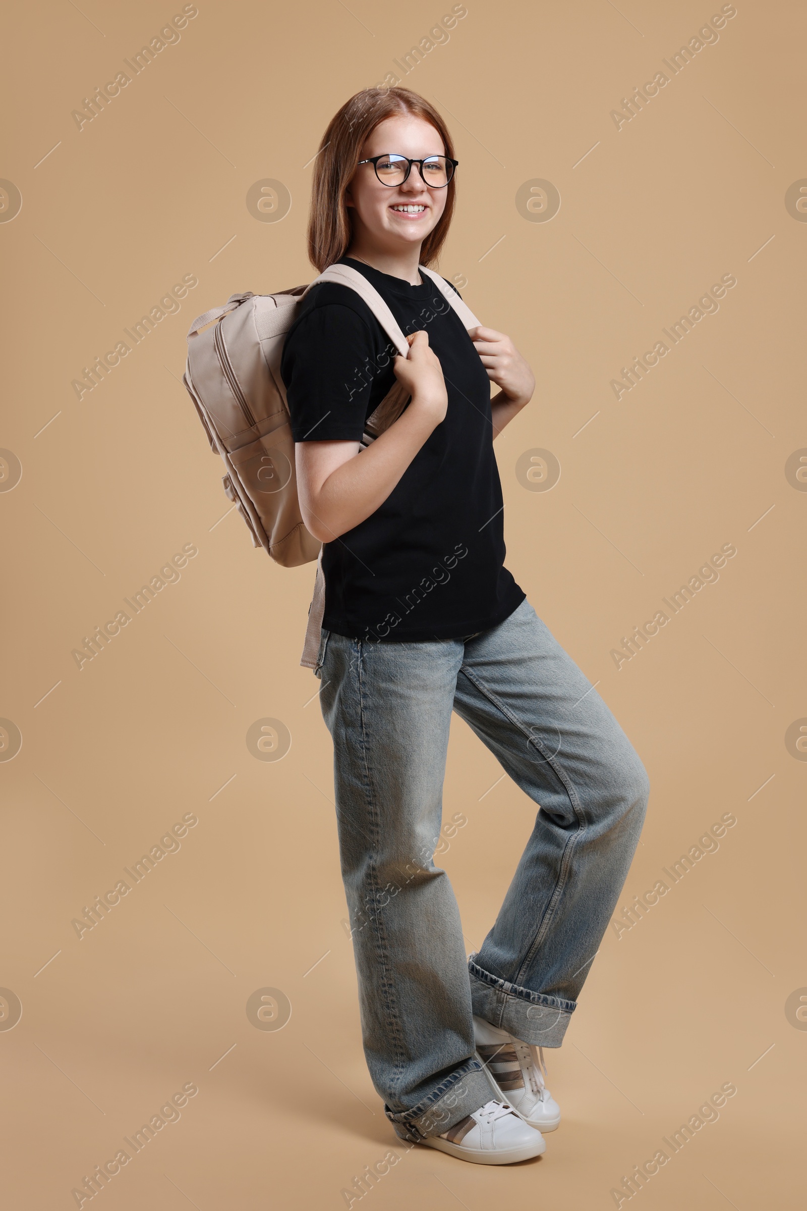 Photo of Teenage girl with backpack on beige background