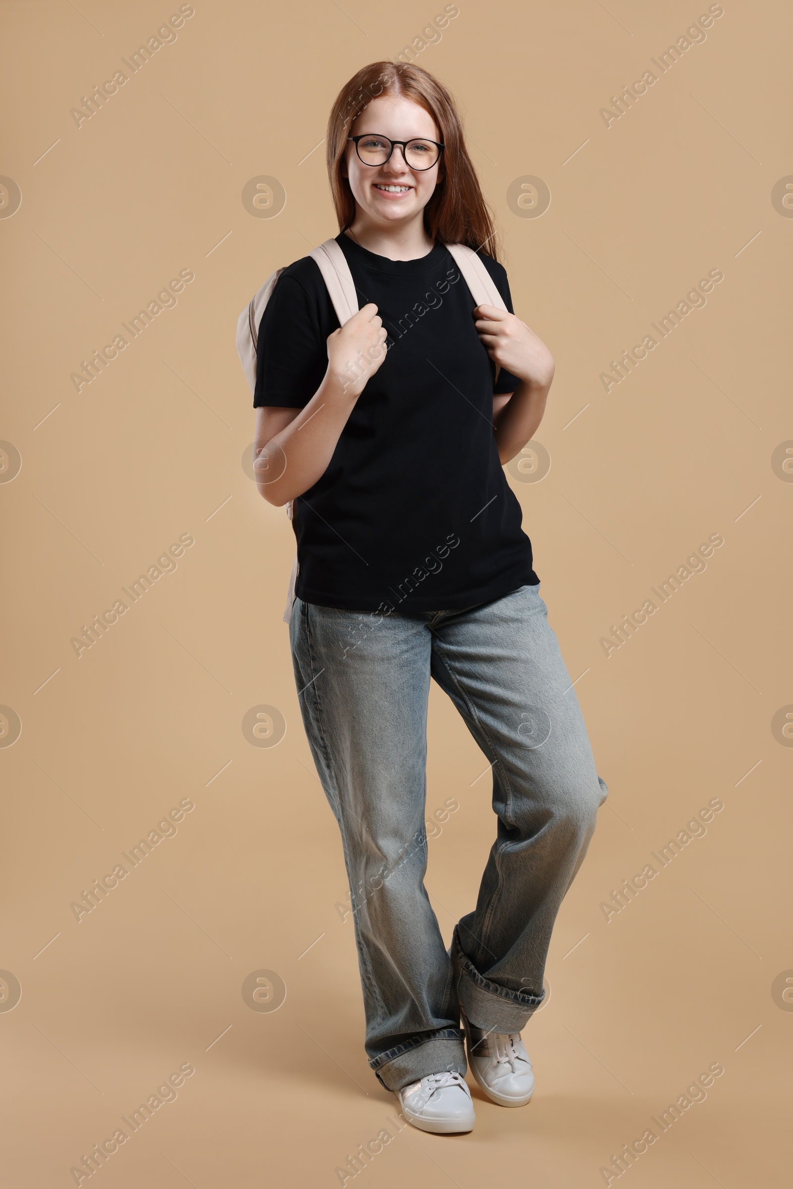 Photo of Teenage girl with backpack on beige background