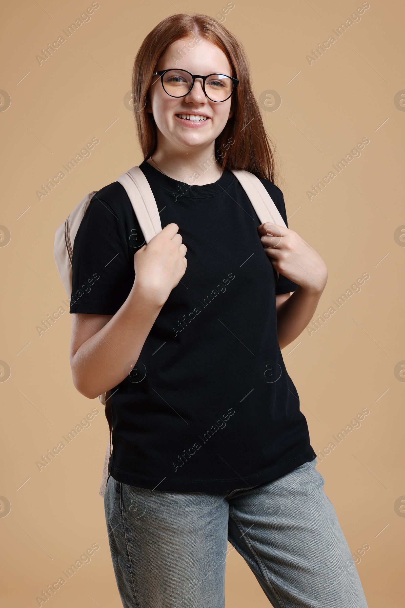 Photo of Teenage girl with backpack on beige background