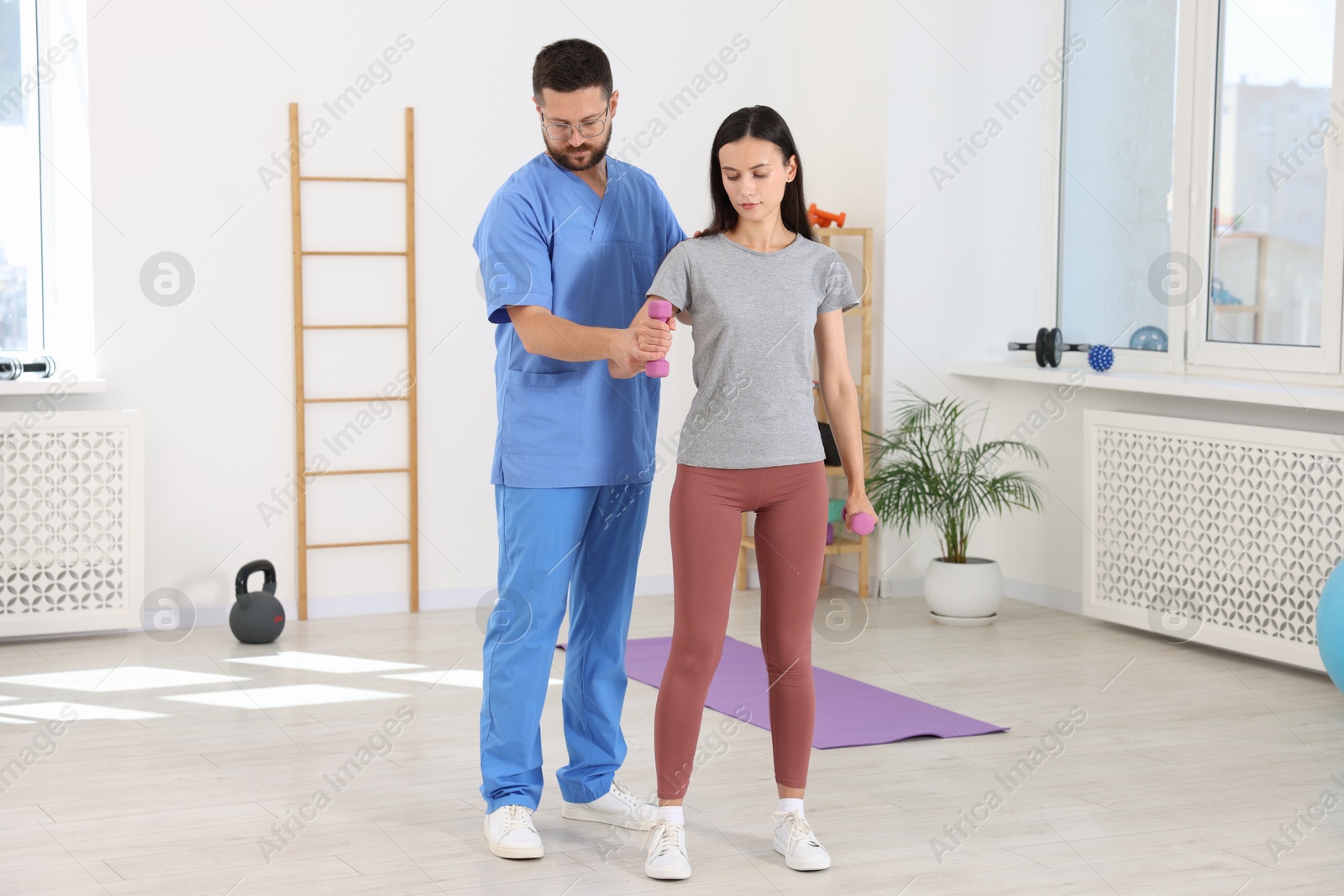 Photo of Patient exercising under physiotherapist supervision in rehabilitation center