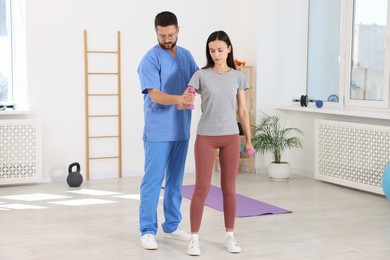 Patient exercising under physiotherapist supervision in rehabilitation center