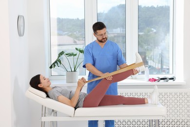 Photo of Physiotherapist working with patient in rehabilitation center