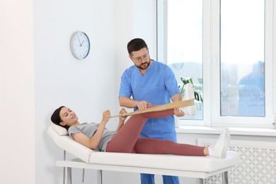 Photo of Physiotherapist working with patient in rehabilitation center