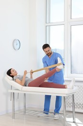 Photo of Physiotherapist working with patient in rehabilitation center