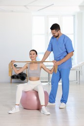 Patient exercising under physiotherapist supervision in rehabilitation center