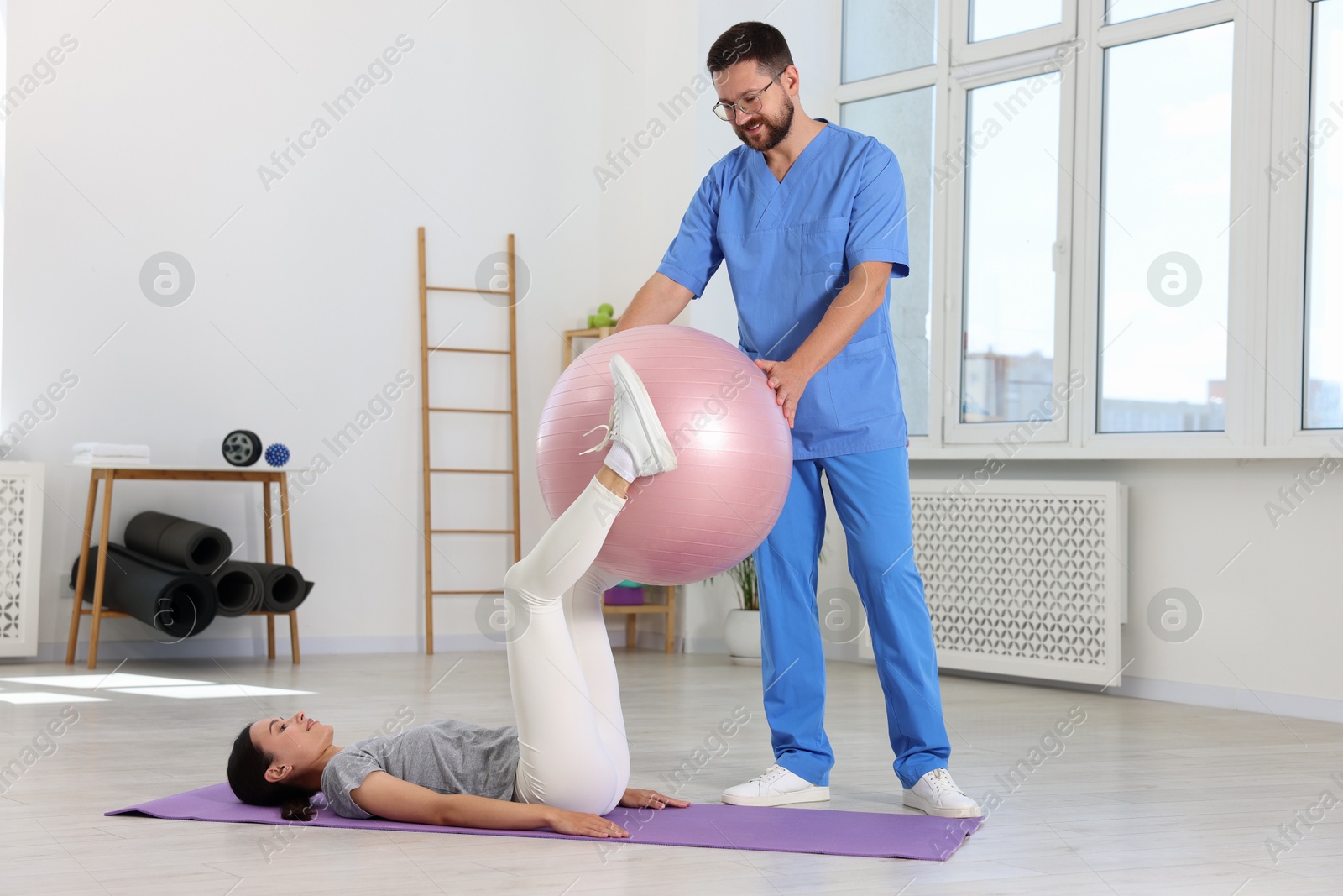 Photo of Physiotherapist working with patient in rehabilitation center