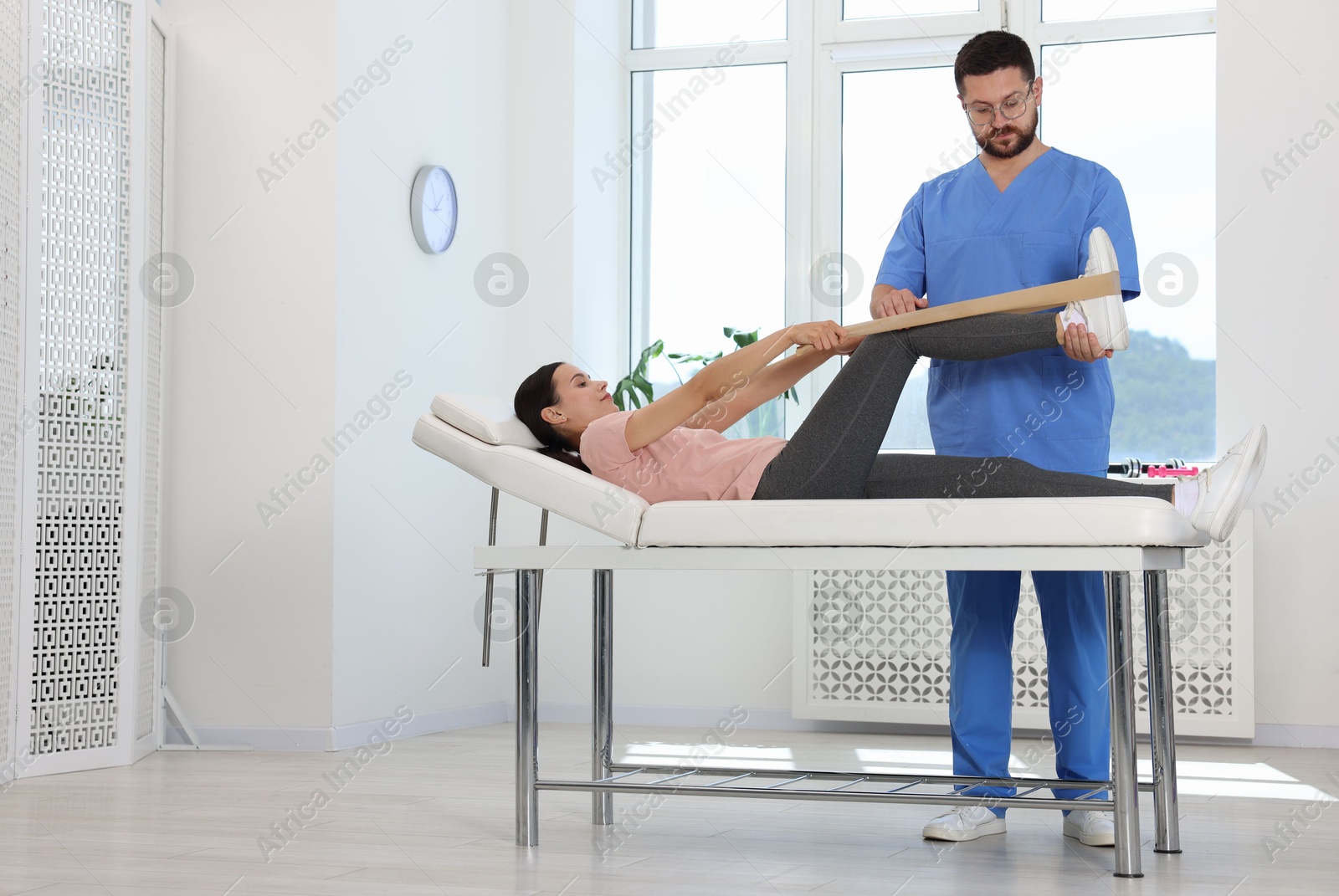 Photo of Physiotherapist working with patient in rehabilitation center