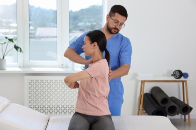 Photo of Physiotherapist working with patient in rehabilitation center