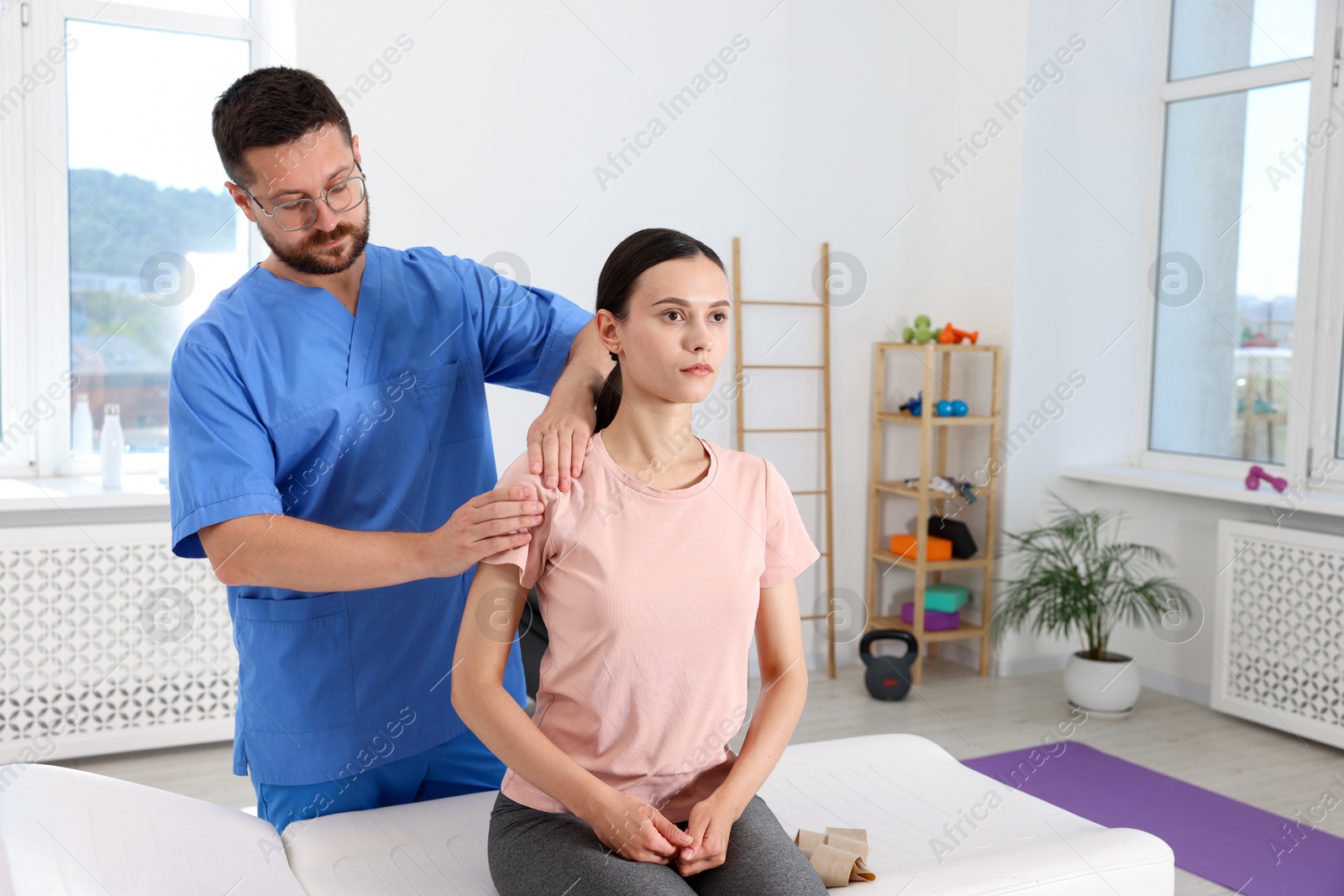 Photo of Physiotherapist working with patient in rehabilitation center