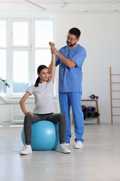 Photo of Physiotherapist working with patient in rehabilitation center