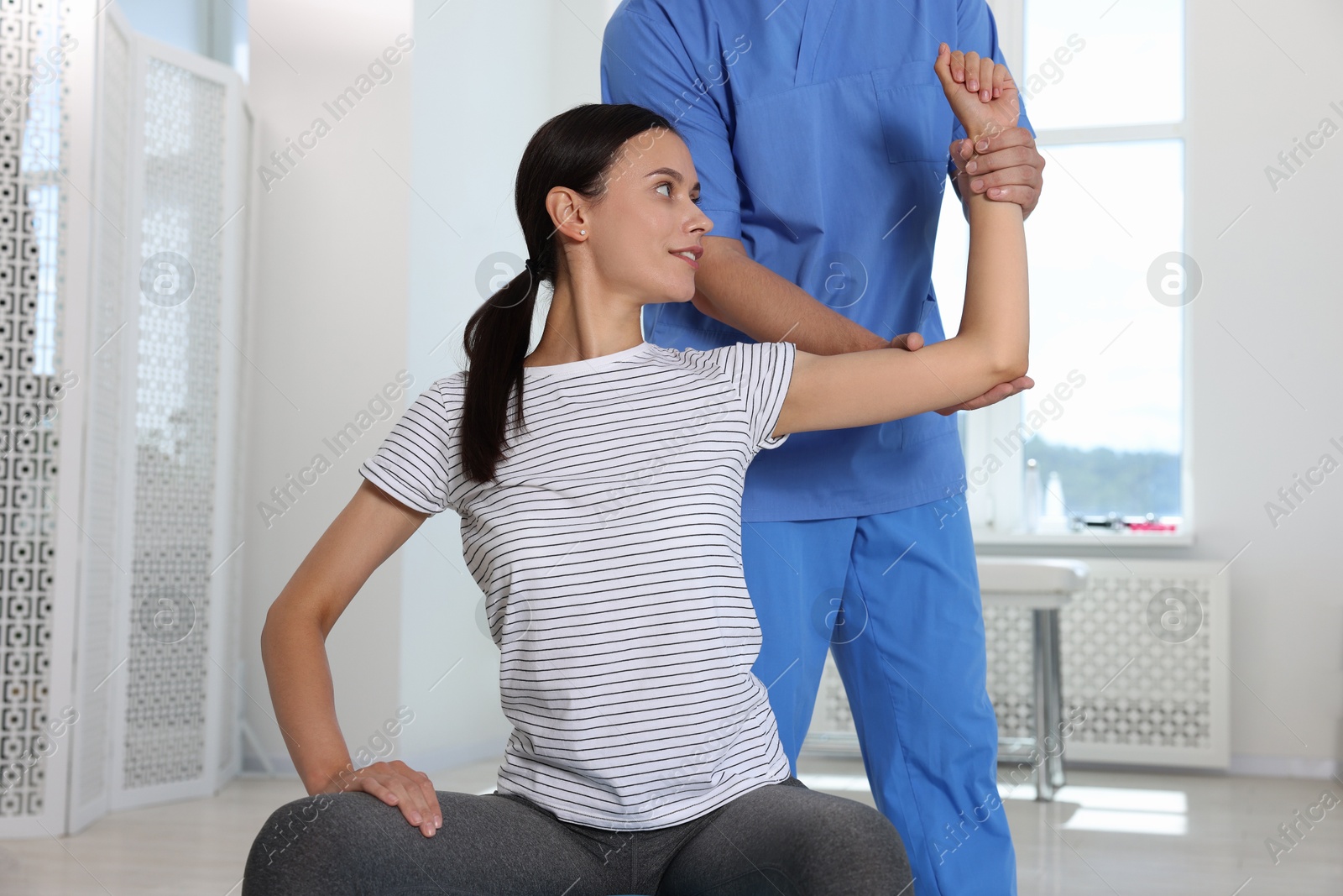 Photo of Physiotherapist working with patient in rehabilitation center