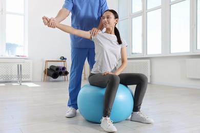 Photo of Physiotherapist working with patient in rehabilitation center