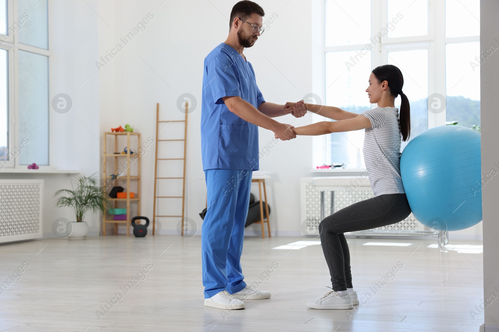 Photo of Physiotherapist working with patient in rehabilitation center