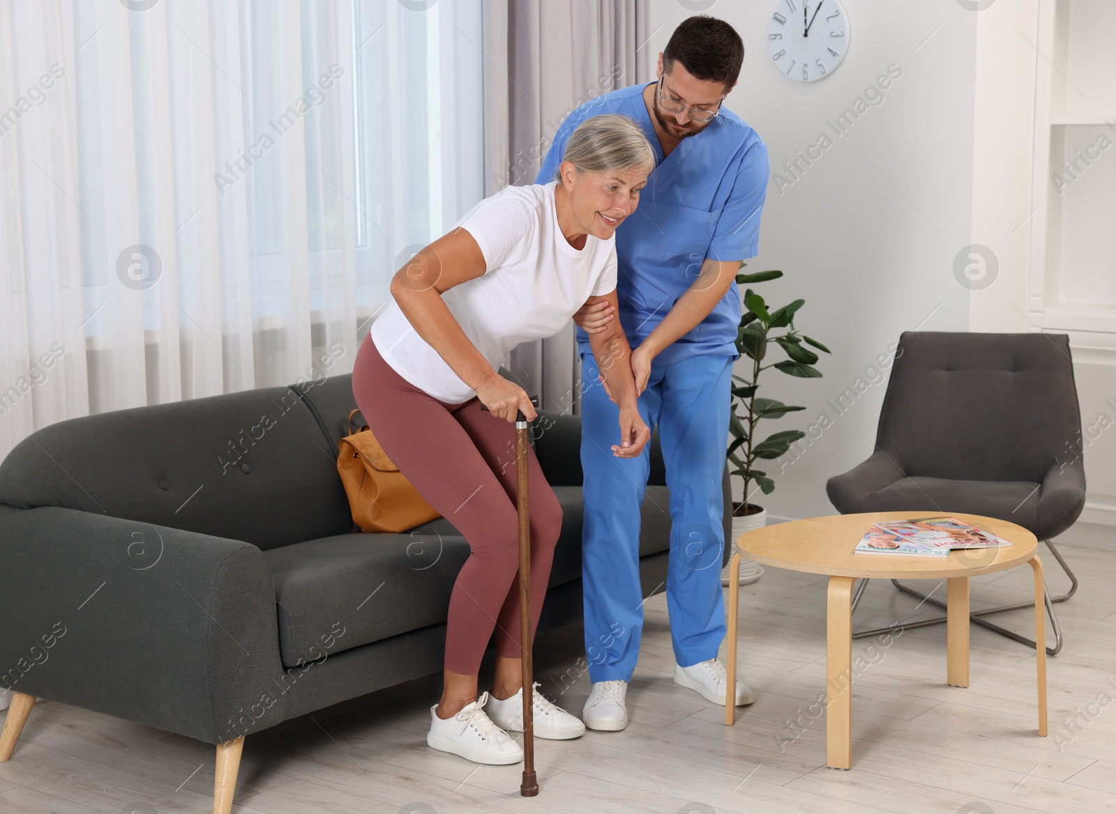 Photo of Rehabilitation. Physiotherapist working with senior patient indoors