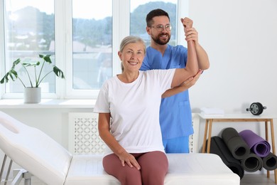 Physiotherapist working with senior patient in rehabilitation center