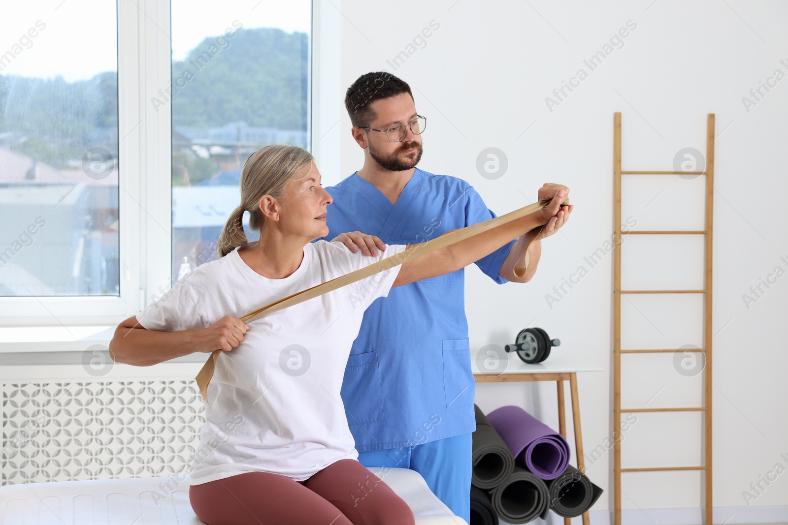 Photo of Senior patient exercising under physiotherapist supervision in rehabilitation center