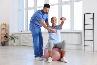 Photo of Senior patient exercising under physiotherapist supervision in rehabilitation center