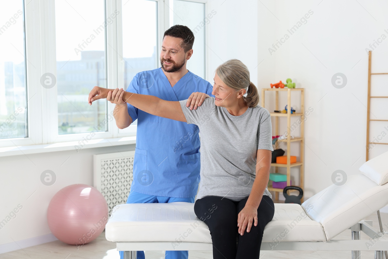 Photo of Physiotherapist working with senior patient in rehabilitation center