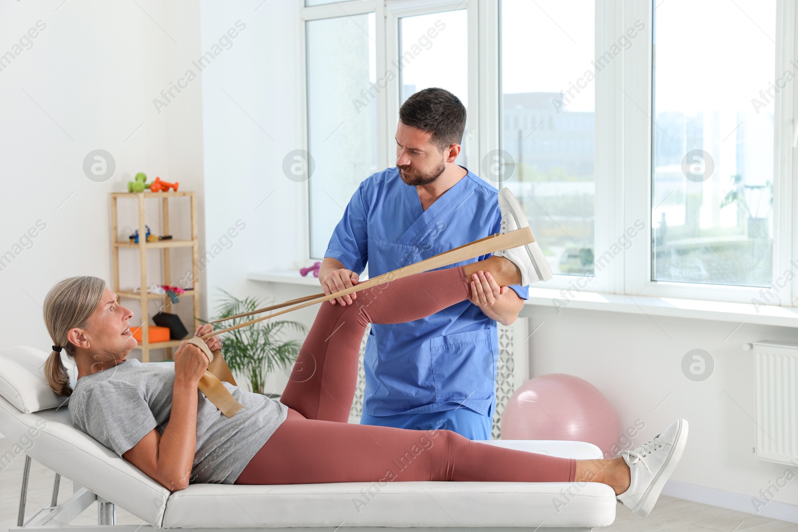 Photo of Physiotherapist working with senior patient in rehabilitation center