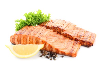 Photo of Delicious grilled salmon fillets with peppercorns, lemon and lettuce isolated on white