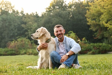 Photo of Smiling man with cute Golden Retriever dog on spring day