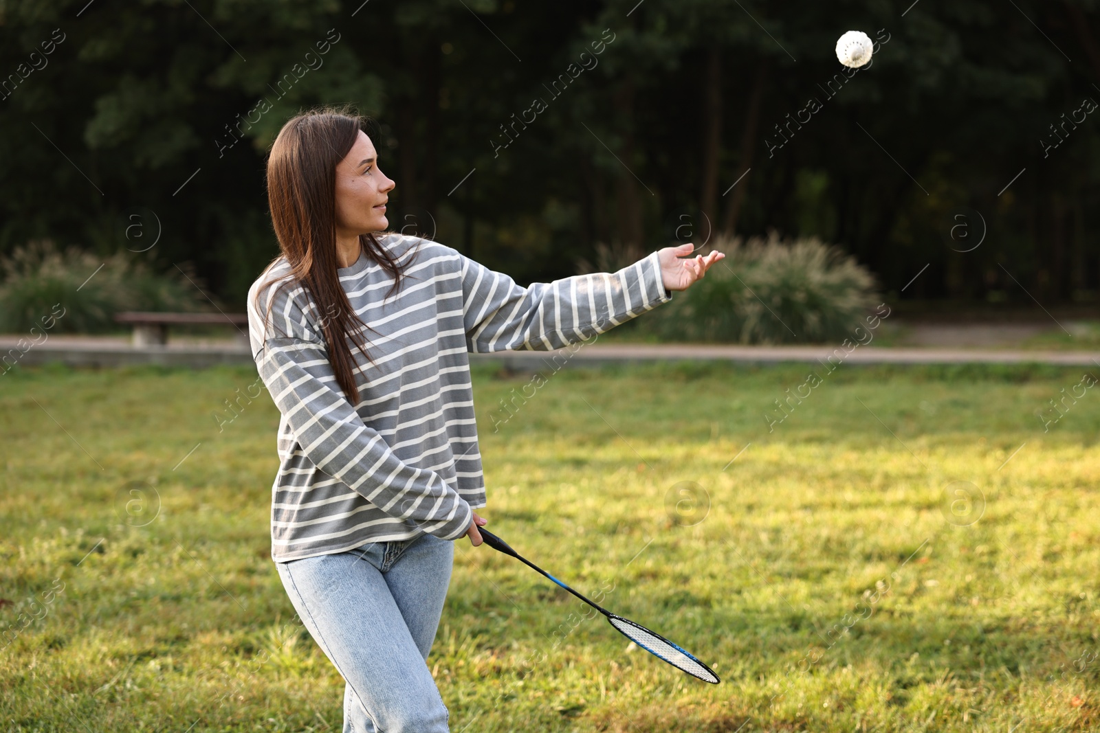 Photo of Young woman playing badminton racket in park