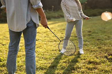 Photo of Woman and man playing badminton in park on sunny day, closeup