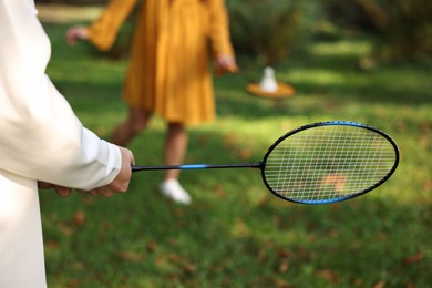 Photo of Young man and woman playing badminton in park, closeup