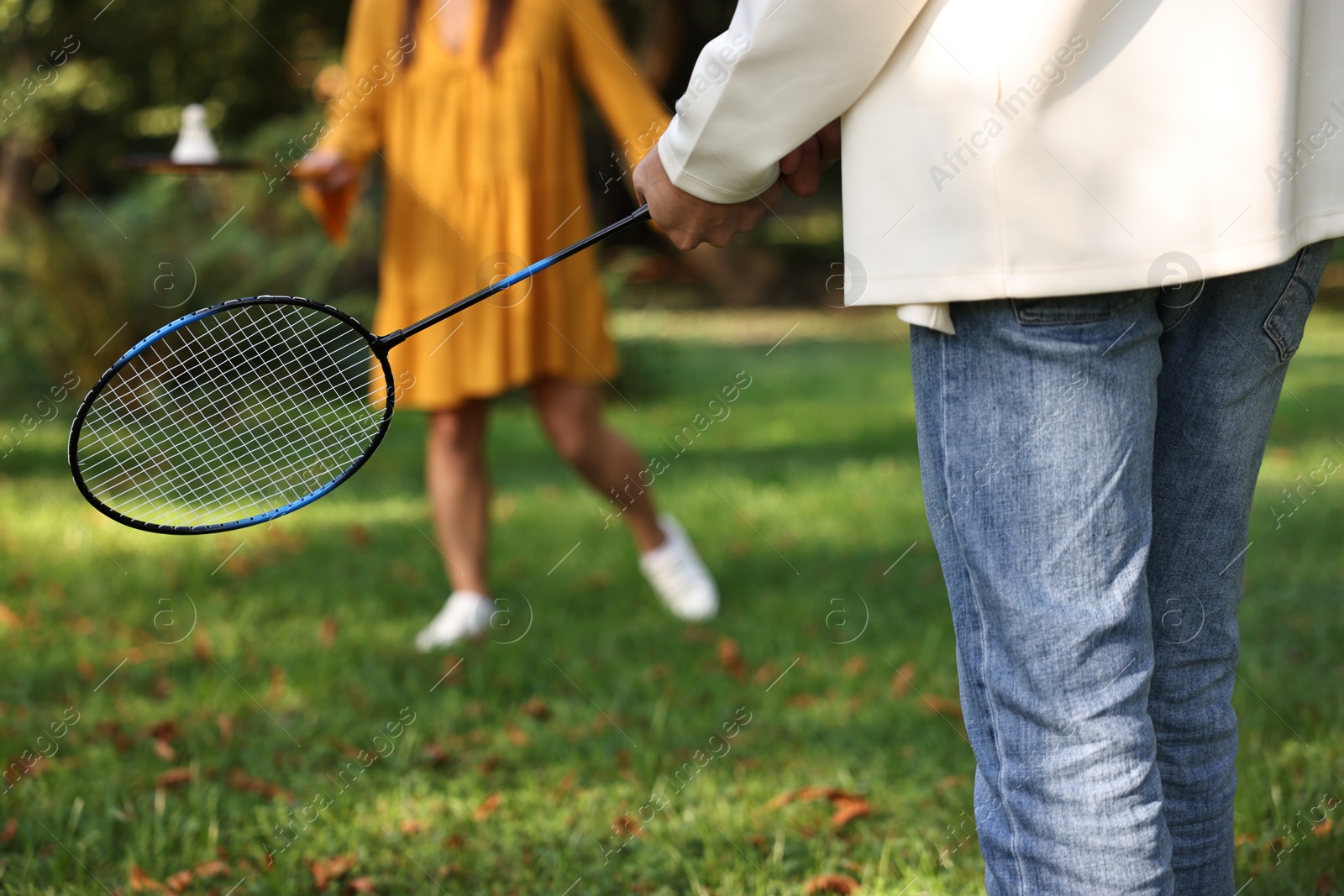 Photo of Young man and woman playing badminton in park, closeup