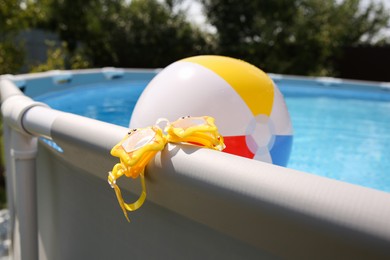 Photo of Swimming goggles for kids on top rail of pool, closeup