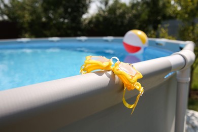 Photo of Swimming goggles for kids on top rail of pool, closeup