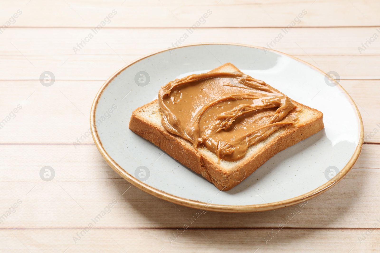 Photo of Delicious sandwich with peanut butter on white wooden table