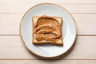 Photo of Delicious sandwich with peanut butter on white wooden table, top view