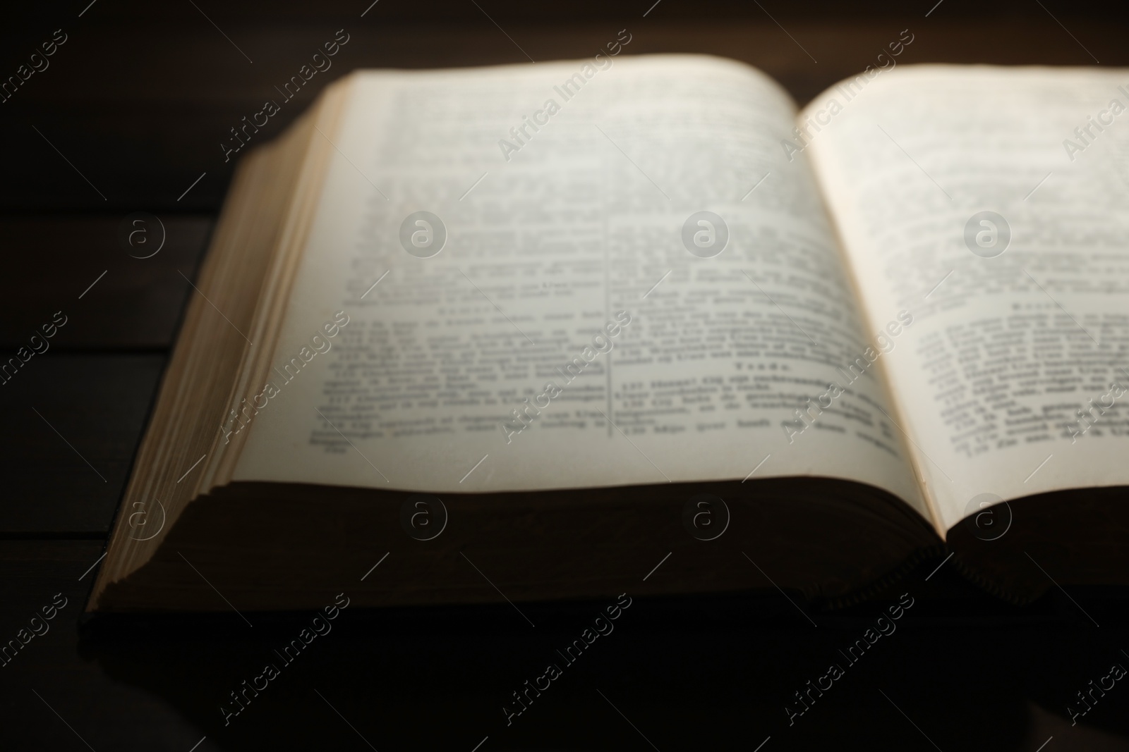 Photo of Open Bible on wooden table, closeup. Christian faith