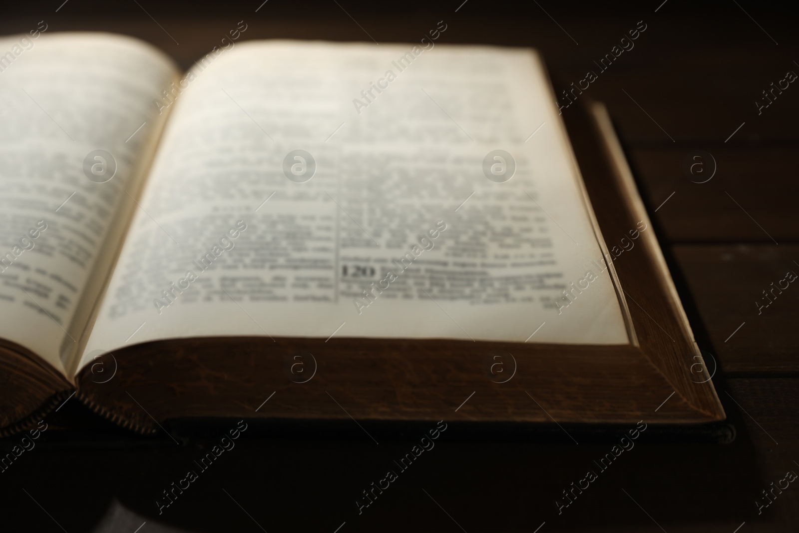 Photo of Open Bible on wooden table, closeup. Christian faith