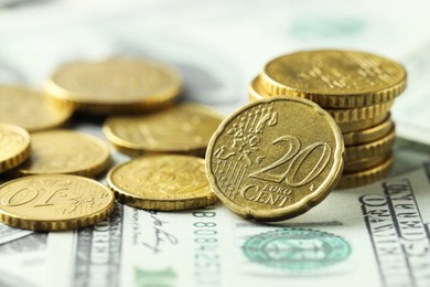 Photo of Many euro coins on dollar banknotes, closeup