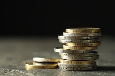 Photo of Stacked euro coins on grey table, closeup