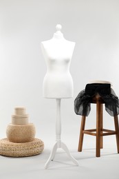 One female mannequin, poufs, stool and boxes on light background