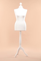 Photo of One female mannequin on stand against beige background