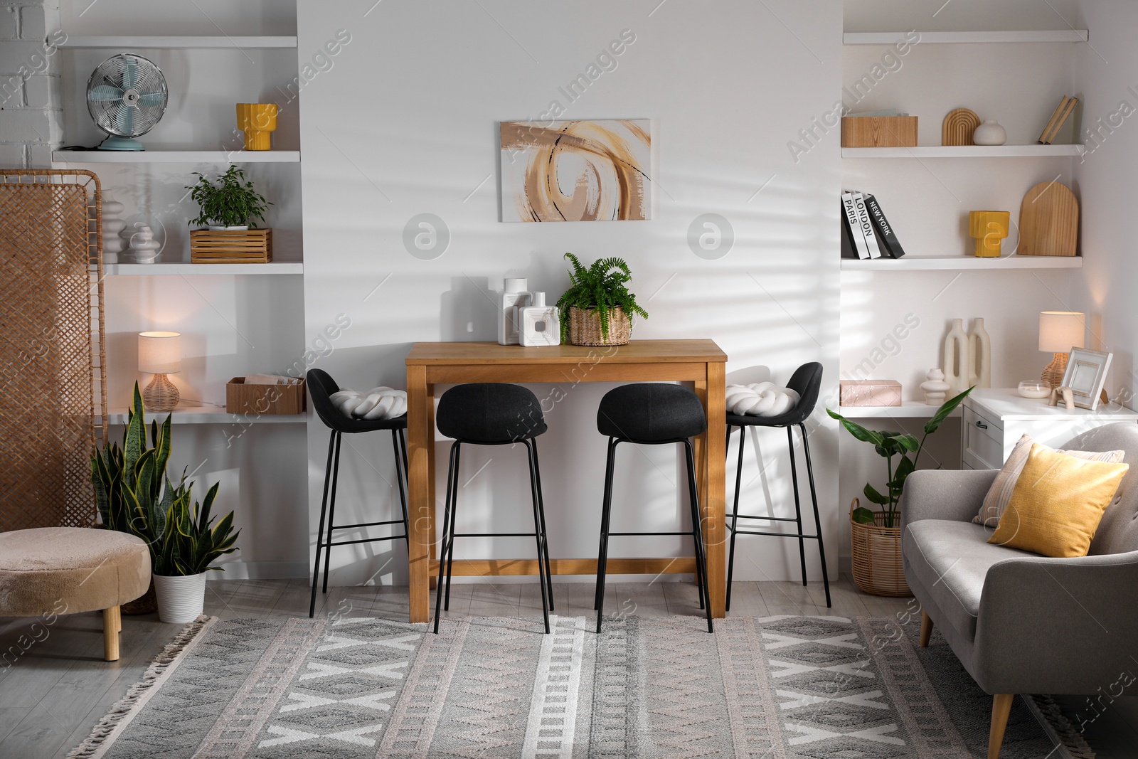 Photo of Bar stools near table in room. Interior design