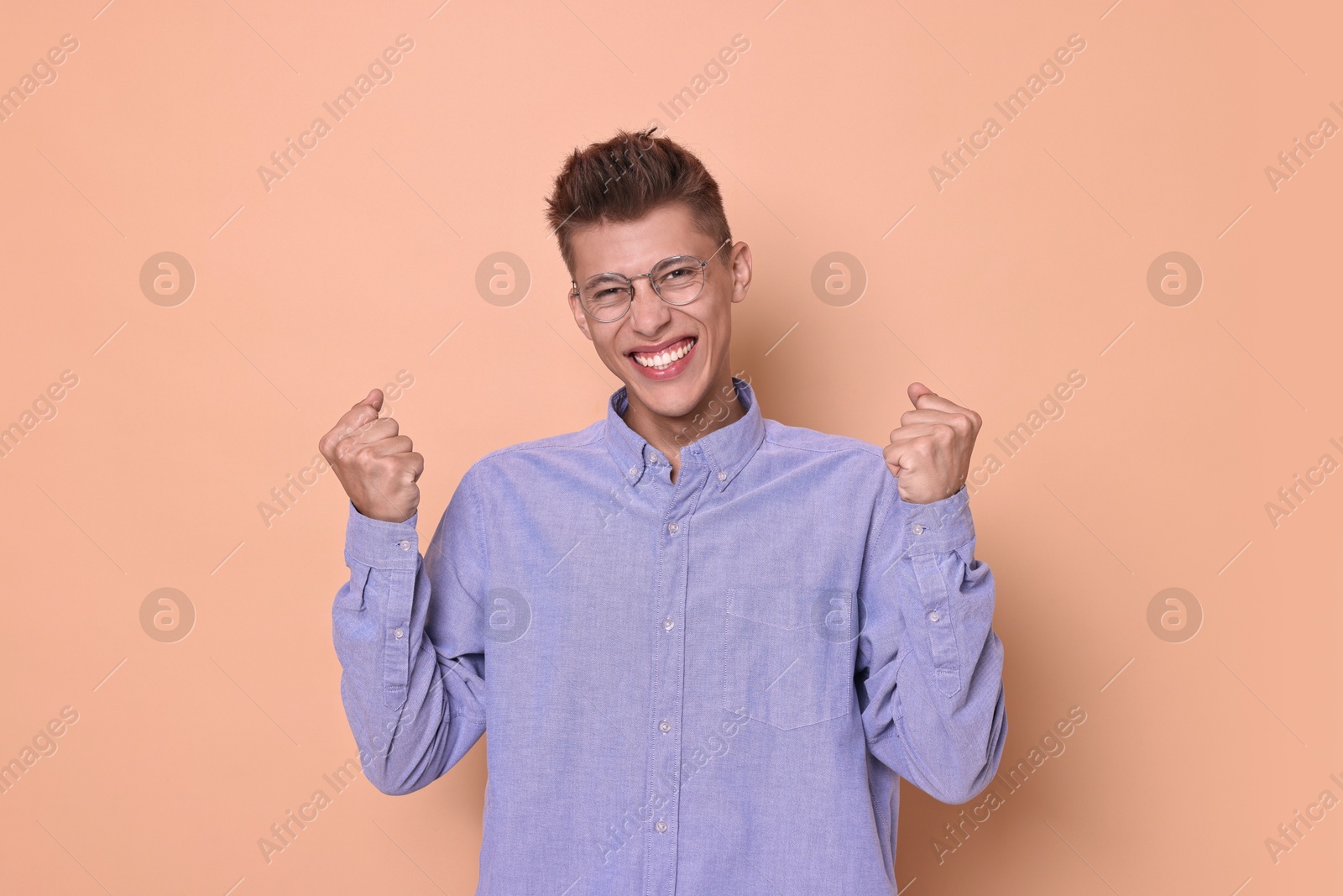 Photo of Happy young student in glasses on beige background